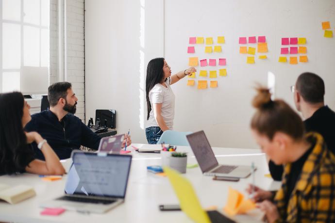 A person placing sticky notes on a wall during a working session